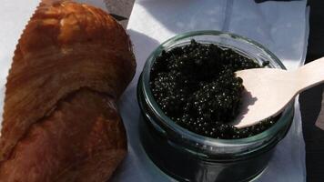 nourriture sur le rue pique-nique collecte noir caviar de une pot, endroit il sur une pièce de bois, et manger il. video