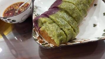 Vietnamese New Year rice cake made of sticky rice and colorful stripes of women's hands unwinding on the festive table Vietnamese Asian food video