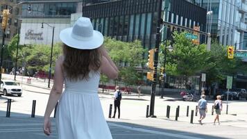 Girl tourist in a white hat walks through the city of Vancouver Canada video