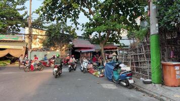 Vietnam ho chi minh città 18.05.2024 vero vita nel il città persone su moto e biciclette studenti studenti ottenere casa nel il sera dopo scuola tramonto video