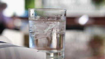 Ice water in a glass scene of stirring a glass of ice and water at a desk. video