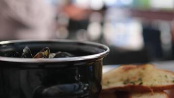 tjänande musslor i en panorera tjänande och dekorera gott måltid med musslor och krämig sås i restaurang med skaldjur video