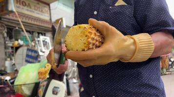 descamação uma abacaxi vendendo abacaxi em a rua do ho chi minh cidade Vietnã, uma pobre homem traz fruta a partir de uma bicicleta e vende isto video