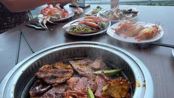 Korean Barbecue in Thai Style,Thai BBQ,pork grill and vegetables on the hot pan. Grill frying meat on a table in a Vietnamese restaurant video