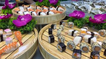 Sushi buffet Service staff of the restaurant guests. Dinner buffet style. The cook holds a plate in his hands and puts different types of Japanese sushi and fish with wooden sticks. video