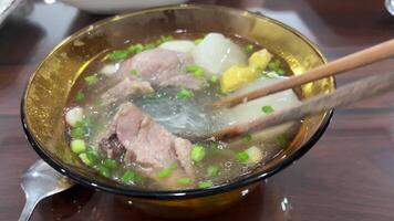 bicchiere vermicelli brodo asiatico la minestra pho eccitante e risciacquo cellofan tagliatelle , funchose, fensi nel freddo acqua con bacchette. cucinando tradizionale Cinese cibo. asiatico cucina video