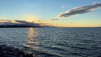 puesta de sol en el Oceano horizonte muchos nubes y brillante colores desde el Dom en el cielo lento movimiento adecuado para música relajación antecedentes para texto silencio paz parquesville playa lado del surf rv recurso video