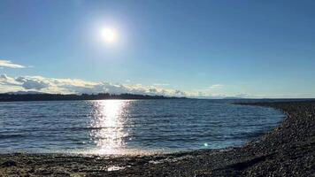 das Sonne ist Rahmen Über das Stein Strand das Reflexionen Pazifik Ozean ist sehr ruhig und Ruhe Dort sind Nein Wellen entspannend Musik- Hintergrund zum Titel und Werbung Parksville Strand Surfside rv Resort video