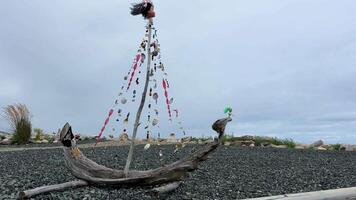 Fait main navire fabriqué de sec branches coquillage perles et une pirate drapeau contre le toile de fond de le océan le vent coups le brillant cheveux de le tête cette est usé à le principale rencontre endroit pour texte video