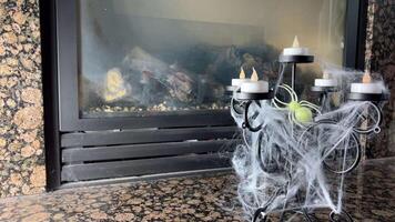 artificial velas en candelabros resplandor en contra el antecedentes de un hogar ellos son todas en un web un araña se sienta en ellos el viento golpes, el web desarrolla de miedo y Siniestro video