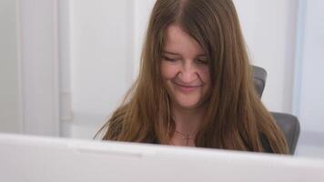 long hair black clothes white computer laptop young woman sits at a computer at the reception of a white light office hospital dentistry any computer programmers video