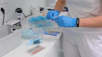 Portrait of a doctor in mask with a syringe Insulin syringe for anesthesia nurse unpacks Global vaccination liquid bottle from table for injection. Insulin syringe with a needle lies on the table video