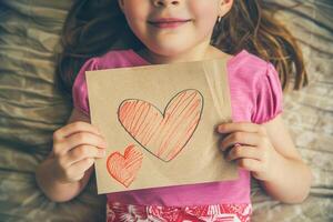 Little girl giving her hand writing greeting card to her mom. photo