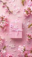 Pink gift box with spring flowers on pink background. photo