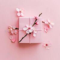 Pink gift box with spring flowers on pink background. photo