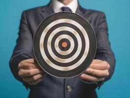 Businessman holding a dart target, dartboard, business goal concept. photo