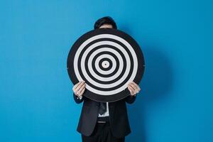 Businessman holding a dart target, dartboard, business goal concept. photo