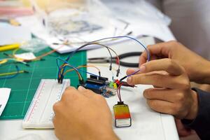 Students experiment with simple electronic circuits. Principles of traffic light circuits. Soft and selective focus. photo