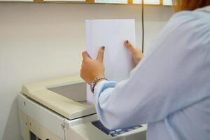 The secretary prepares paper to load into the copy machine tray. soft and selective focus. photo