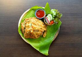 Minced Pork Omelette with Rice, served with tomato sauce and various vegetables, Thai street food menu. photo