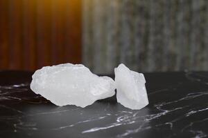 Lumps of alum on a black background and an old zinc sheet background. It is a mineral with clear, white crystals, odorless, astringent taste, ground into a white powder that resembles rock sugar. photo