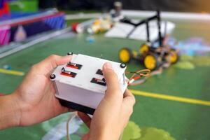Asian high school students practice moving robots on the playing field To perform missions according to the rules of the robot competition. Soft and selective focus. photo