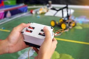 asiático alto colegio estudiantes práctica Moviente robots en el jugando campo a realizar misiones según a el reglas de el robot competencia. suave y selectivo enfocar. foto