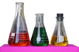 Isolated Erlenmeyer flasks containing red yellow and green solution on a white background. photo