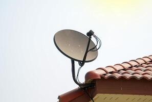 Satellite dish installed on the roof of the house for receiving television waves. Soft and selective focus. photo