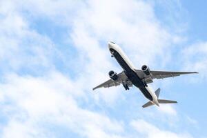 White passenger airplane flying in the sky amazing clouds in the background photo