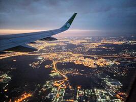 un instantánea de el ciudad a noche desde el altura de el del avión vuelo foto