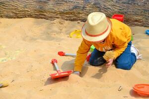 Boy and girl playing on the beach on summer holidays. Children building a sandcastle at the sea. photo