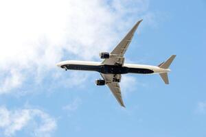 White passenger airplane flying in the sky amazing clouds in the background photo