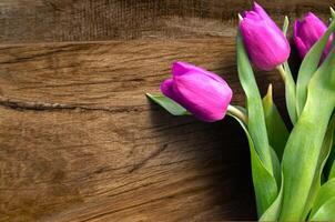 Bouquet of beautiful tulips on wooden background. Tulips on old boards photo