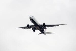 White passenger airplane flying in the sky amazing clouds in the background photo