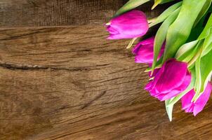 ramo de flores de hermosa tulipanes en de madera antecedentes. tulipanes en antiguo tableros foto