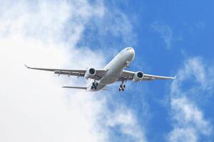 White passenger airplane flying in the sky amazing clouds in the background photo