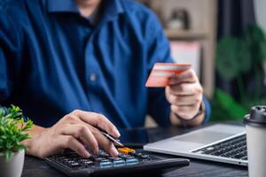 persona calculador gastos utilizando calculadora y crédito tarjeta, indicativo de personal Finanzas administración foto