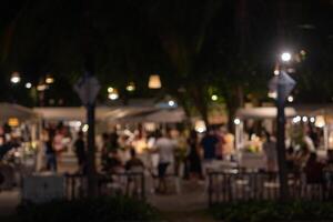 abstract blurred festival food market night light bokeh background. People walking travel street food and stalls photo