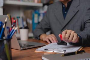 A professional applies an official seal to company documents, signifying authentication and approval. photo