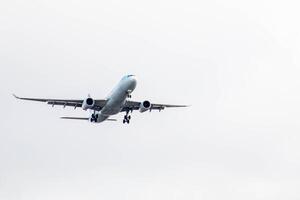 White passenger airplane flying in the sky amazing clouds in the background photo