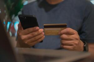 Man holding credit card and smartphone for online shopping, digital payment concept. cellphone app check balance client banking customer transaction photo