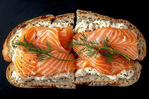 Salmon with cream cheese on toast with dill on a black background. photo