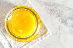 Top view, jar of ghee on a linen napkin with a spoon. photo