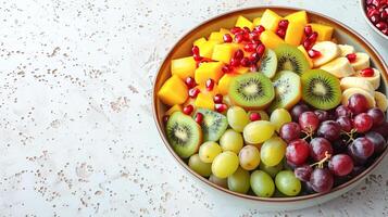 Bowl with fresh fruit salad of fruits on a light background. photo