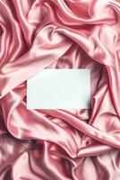 Minimalist aesthetic mockup of white blank A5 envelope on pink silk fabric. photo