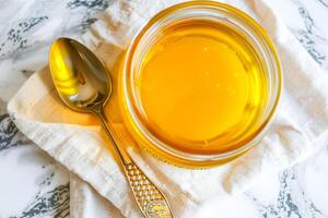 Top view, jar of ghee on a linen napkin with a spoon. photo