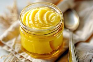 Top view, jar of ghee on a linen napkin with a spoon. photo