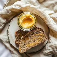 parte superior ver de un tarro de ghee y dos rebanadas de un pan. foto