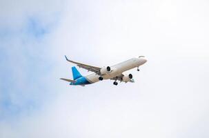 White passenger airplane flying in the sky amazing clouds in the background photo